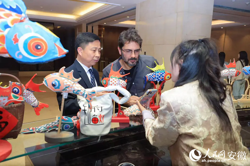 巴西旅行商米内维诺·奥尔蒂斯·内托·西尔维里奥(中)对鱼灯充满好奇。人民网记者 王晓飞摄