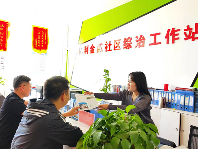 居民到社区综治工作站咨询惠民政策。