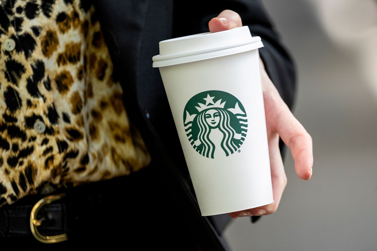 A person holds a Starbucks cup.