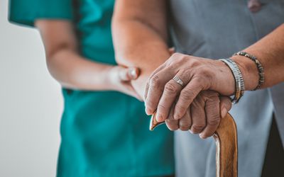 woman in nursing home helping elderly woman